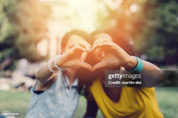 girls making heart with hands - black heart symbol stock pictures, royalty-free photos & images