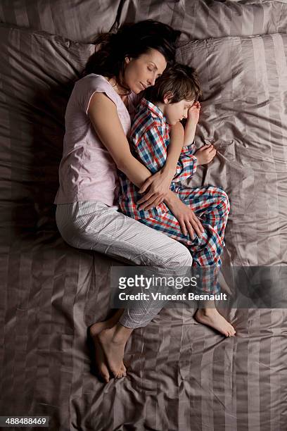 woman sleeping in bed with her son - vincent young stock pictures, royalty-free photos & images