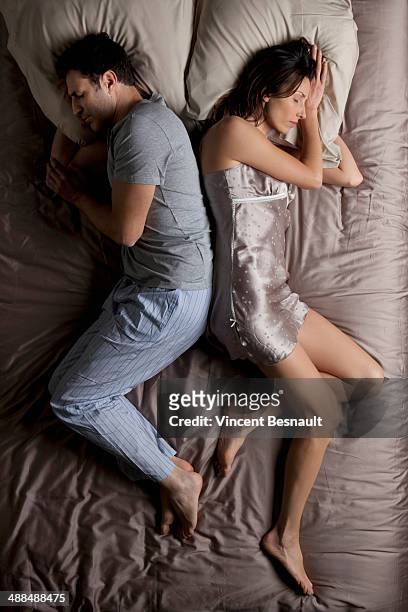woman and a man lying back to back in bed - above view of man sleeping on bed stock pictures, royalty-free photos & images