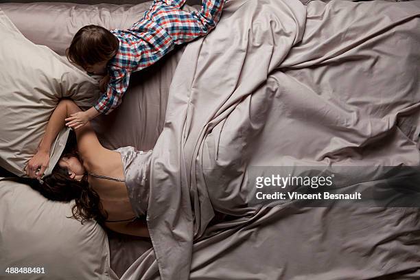 woman lying in a bed with her children - two boys in bed stock pictures, royalty-free photos & images