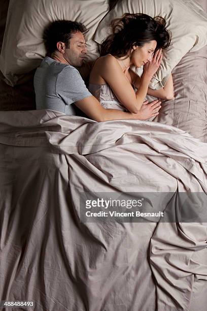 woman and a man sleeping in bed - suresnes stock pictures, royalty-free photos & images