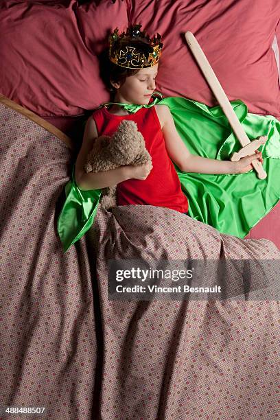 child dressed as a king sleeping in bed - beds dreaming children stock pictures, royalty-free photos & images