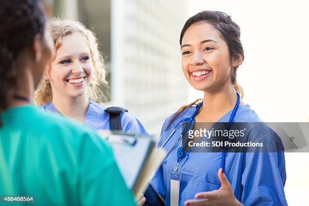nursing students talking together on college campus - nurse talking stock pictures, royalty-free photos & images