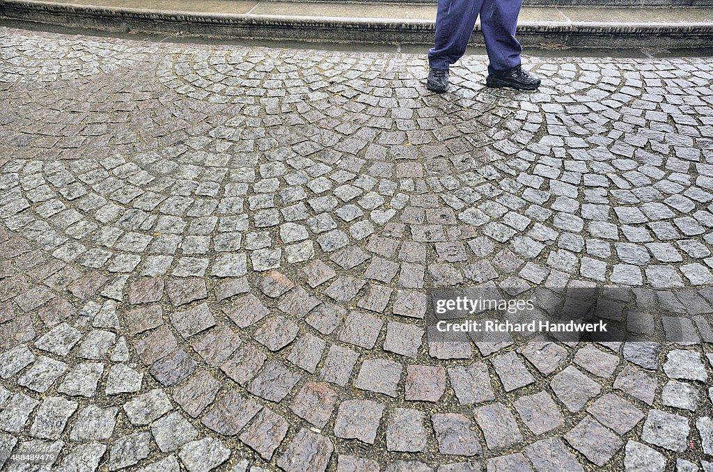 Detail of legs walking on cobblestone street