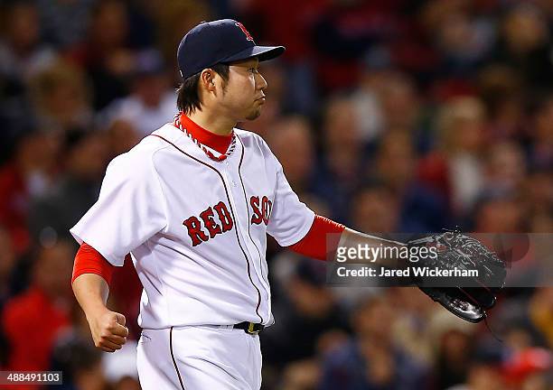 Junichi Tazawa of the Boston Red Sox reacts after giving up a run in the 8th inning against the Cincinnati Reds during the interleague game at Fenway...