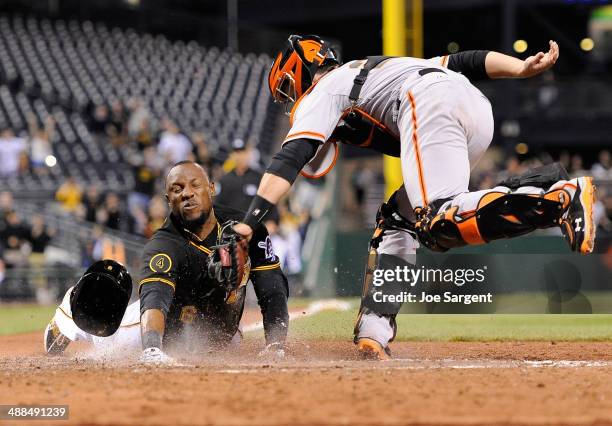 Starling Marte of the Pittsburgh Pirates slides safely into home plate to score the game winning run in front of Buster Posey during the ninth inning...