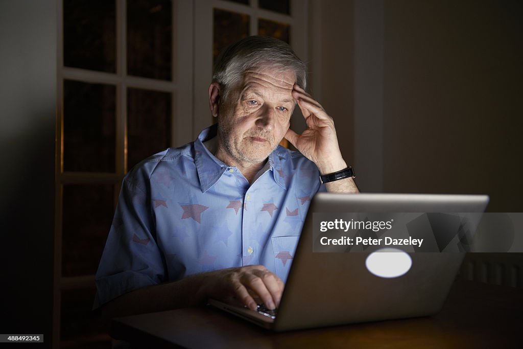 Senior man working late