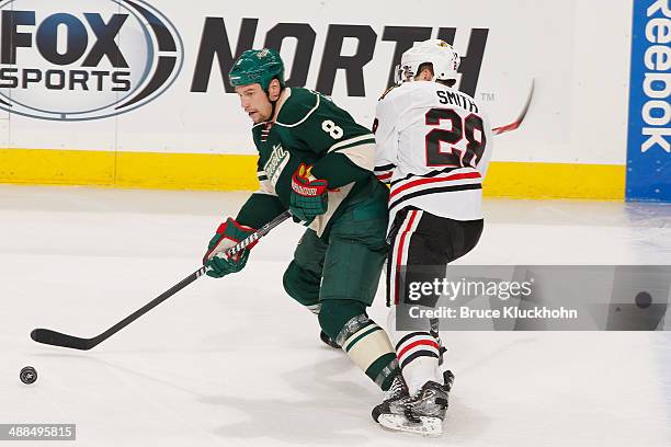 Cody McCormick of the Minnesota Wild handles the puck with Ben Smith of the Chicago Blackhawks defending during Game Three of the Second Round of the...