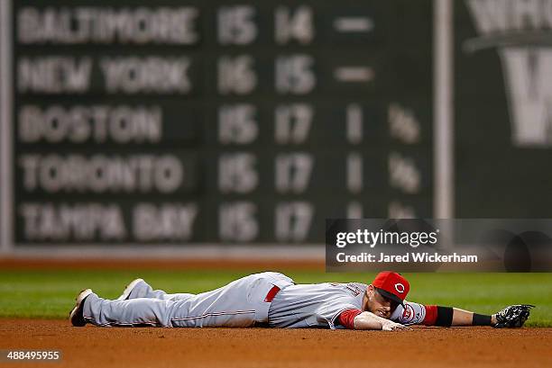 Zack Cozart of the Cincinnati Reds lays on the infield dirt after coming up short on a ground ball up the middle in the 12th inning against the...