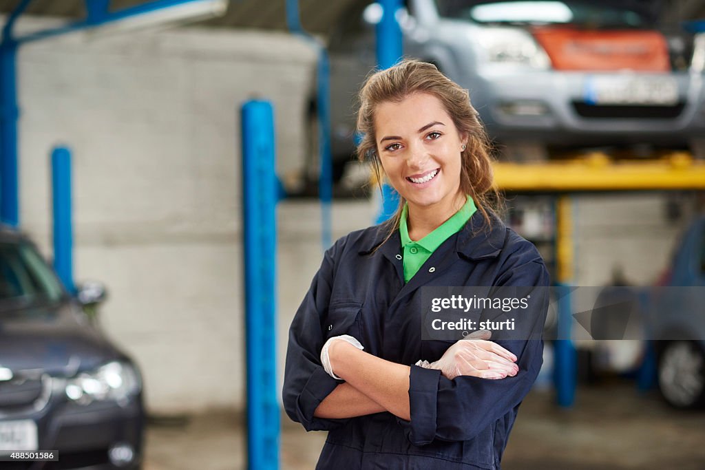 Happy female auto mechanic trainee