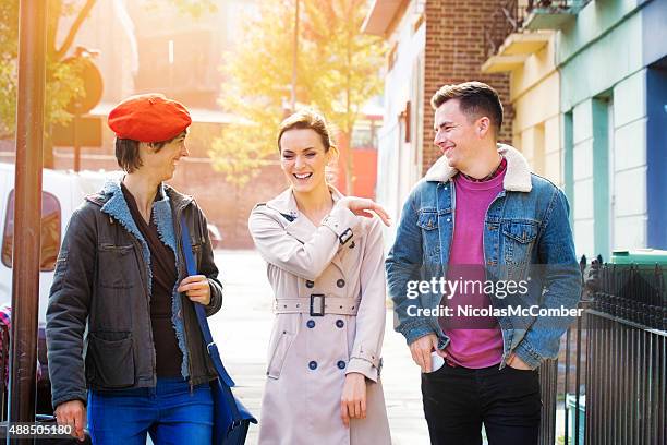 young woman laughs off friend's bad joke street outdoors - embarrassed girlfriend stock pictures, royalty-free photos & images