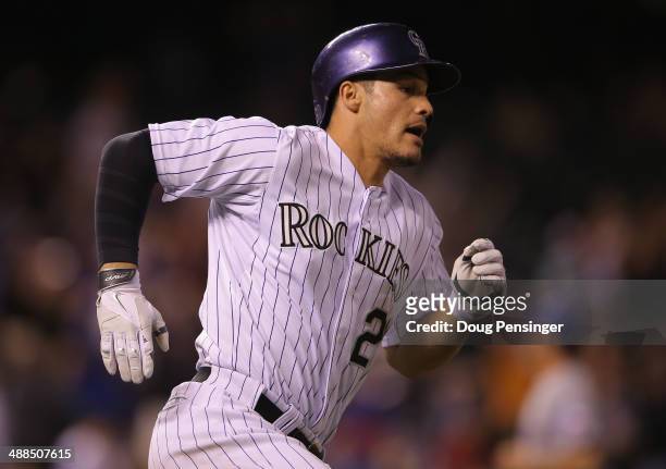 Nolan Arenado of the Colorado Rockies rounds the bases on an RBI double off of Neal Cotts of the Texas Rangers to score Carlos Gonzalez of the...