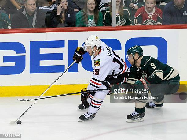 Jonathan Toews of the Chicago Blackhawks controls the puck against Mikko Koivu of the Minnesota Wild during the third period in Game Three of the...