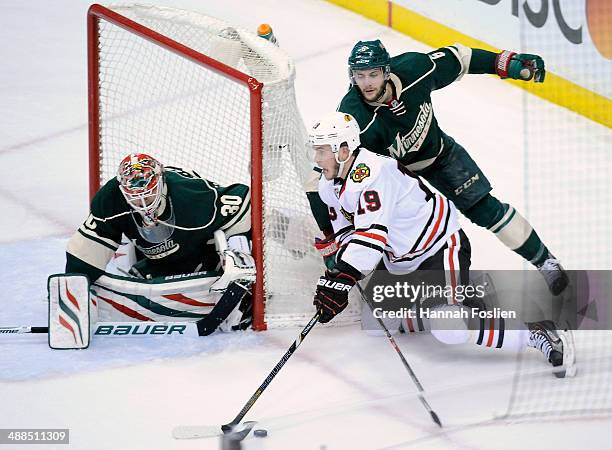 Ilya Bryzgalov of the Minnesota Wild defends the net as Jonathan Toews of the Chicago Blackhawks brings the puck around the net against Marco...