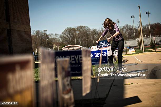 Jill Riveroll of Gainesville, Va drives a campaign sign into the ground among a crowded field before a Mt. Vernon District Democratic candidate forum...