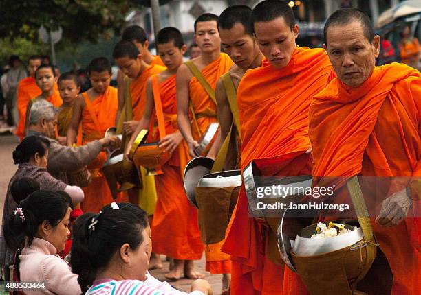 laos: monks begging alms at dawn, luang prabang - alms stock pictures, royalty-free photos & images