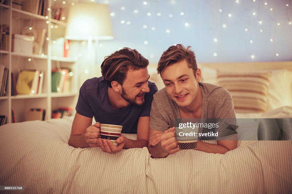 Young gay couple in bedroom.