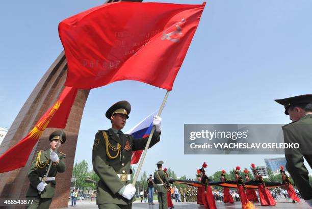 Wearing their traditional costumes young Kyrgyz women carry a huge St. George's Ribbon , a military valor symbol of both Imperial Russia and Soviet...