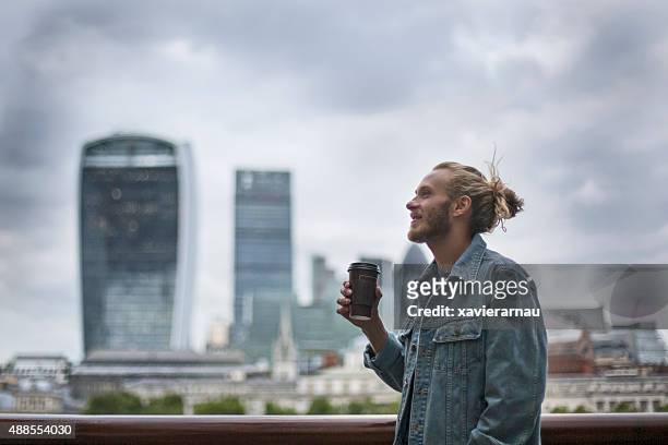 pensive hipster drinking coffee in the street at london - jacket stock pictures, royalty-free photos & images