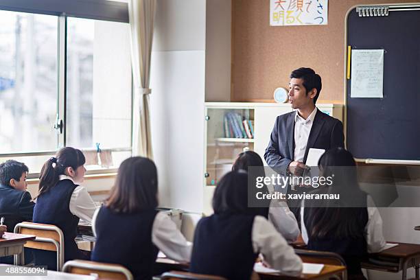 japanese teacher using a digital tablet on his class - japan 12 years girl stock pictures, royalty-free photos & images