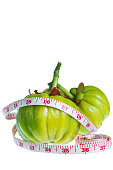 Garcinia cambogia with measuring tape, isolated on white backgro
