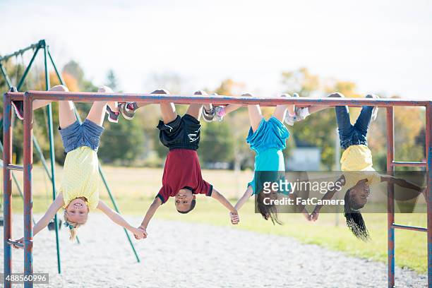 holding hands upside down on monkey bars - jungle gym stock pictures, royalty-free photos & images