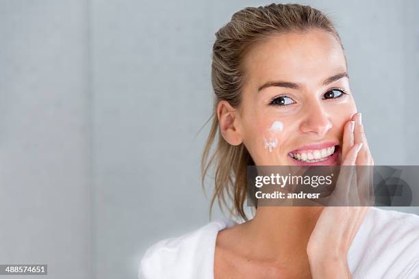 woman using moisturising cream - candid beautiful young woman face stock pictures, royalty-free photos & images