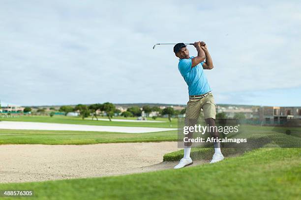 african golfer getting a good shot out of the bunker. - sand trap stock pictures, royalty-free photos & images