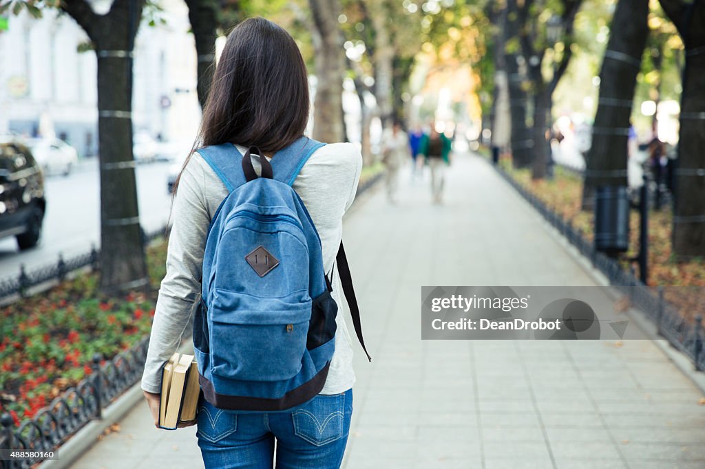 Back view portrait of a female student walking