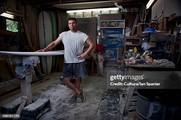 portrait of mature man in his surfboard workshop - standing at attention stock pictures, royalty-free photos & images