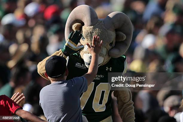 Cam the Ram celebrates with a fan as they support the Colorado State Rams against the Minnesota Golden Gophers at Sonny Lubick Field at Hughes...