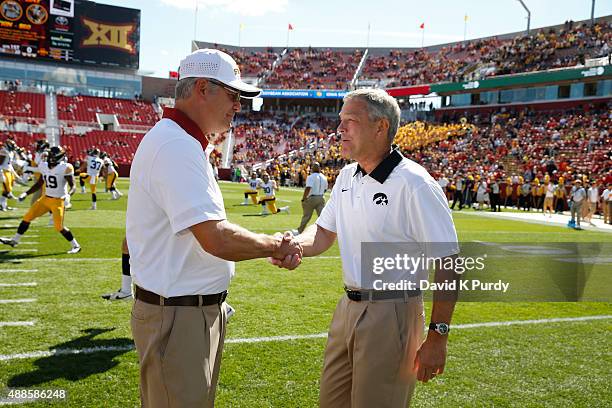 Head coach Paul Rhoads of the Iowa State Cyclones, left, shakes hands with head coach Kirk Ferentz of the Iowa Hawkeyes during pre game warm ups...
