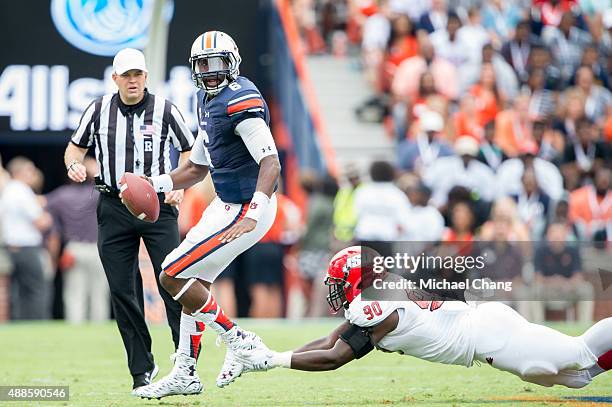 Quarterback Jeremy Johnson of the Auburn Tigers scrambles to escape a tackle by defensive end Chris Landrum of the Jacksonville State Gamecocks on...