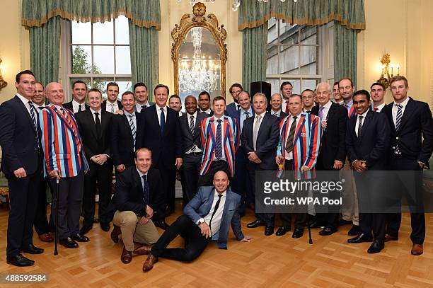 British Prime Minister David Cameron poses with cricketers and veterans of the armed forces at a reception at a reception ahead of tomorrow's Help...