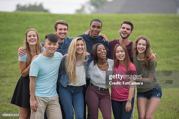 group of friends laughing at the park - teen boy shorts stock pictures, royalty-free photos & images