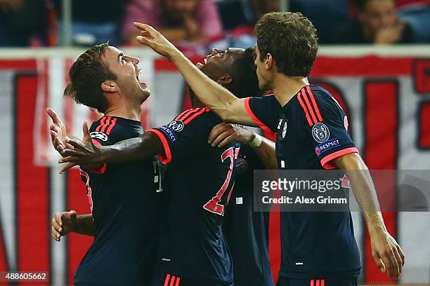 Mario Goetze of Muenchen celebrates his team's second goal with team mates Kingsley Coman and Thomas Mueller during the UEFA Champions League Group F...