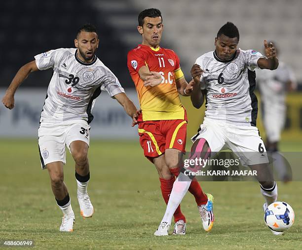 Qatar's Al-Sadd players Nadir Belhadj and Mohammed Kasoula fight for the ball with Bakhtiar Rahmani of Iran's Foolad Khouzestan during their AFC...
