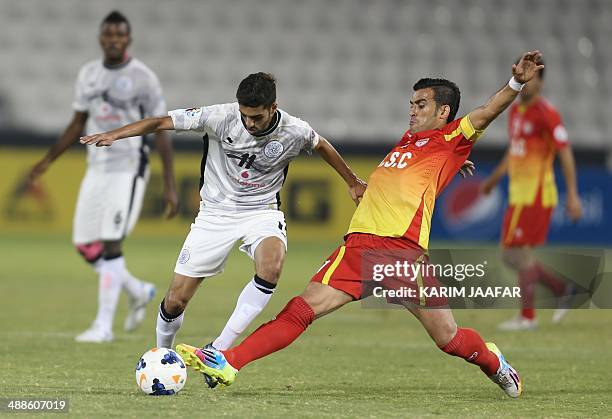 Qatar's Al-Sadd player Hasan Al-Haidous fights for the ball with Bakhtiar Rahmani of Iran's Foolad Khouzestan during their AFC Champions League...