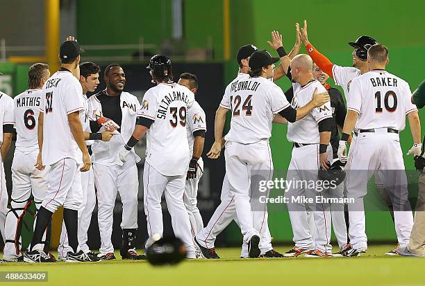 Marcell Ozuna of the Miami Marlins is congratulated after hitting a walk off sacrafice fly during a game against the New York Mets at Marlins Park on...