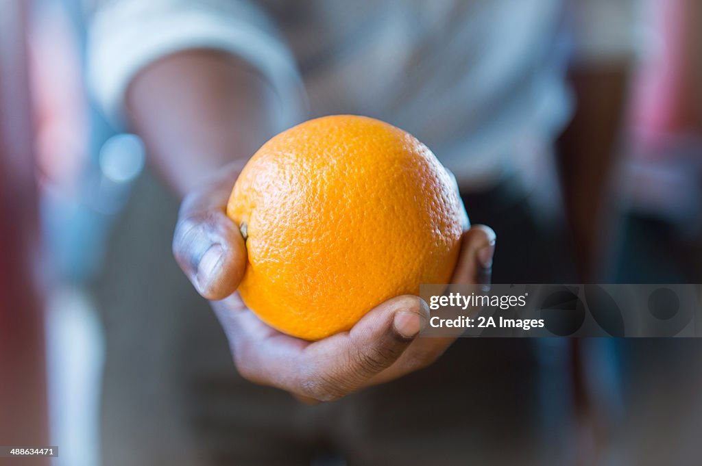 Close-up of hand holding orange  in health store in Johannesburg, South Africa
