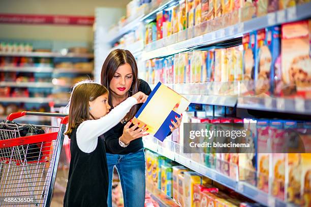 mãe e filha a verificar a rotulagem de alimentos no supermercado - corn flakes imagens e fotografias de stock