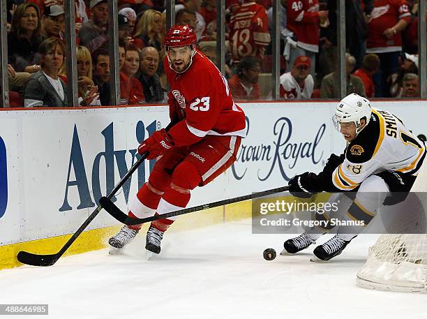 Brian Lashoff of the Detroit Red Wings moves the puck in front of Reilly Smith of the Boston Bruins of Game Four of the First Round of the 2014 NHL...