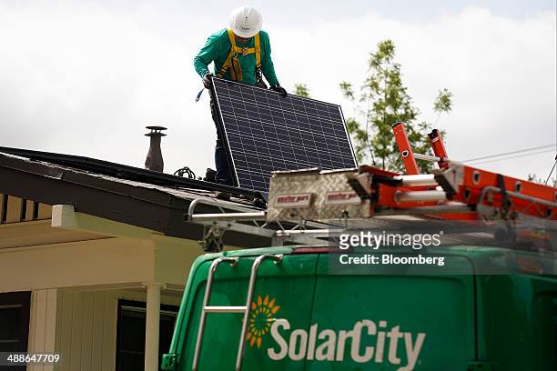 SolarCity Corp. Employee installs a solar panel on the roof of a home in the Eagle Rock neighborhood of Los Angeles, California, U.S., on Wednesday,...