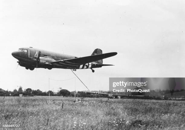 American glider is about to be picked up from a poppy field in France, by a transport plane, June 1944. This was the first snap take-off on the...