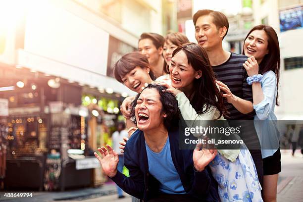 junge menschen abhängen gegen stadtbild, tokio. - tokyo travel destinations stock-fotos und bilder