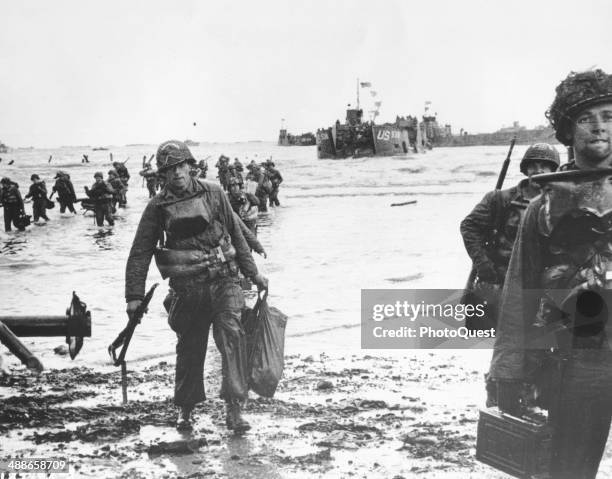 American assault troops carrying full equipment move onto a beachhead on the northern coast of France, Omaha Beach, June 6, 1944. The landing craft,...