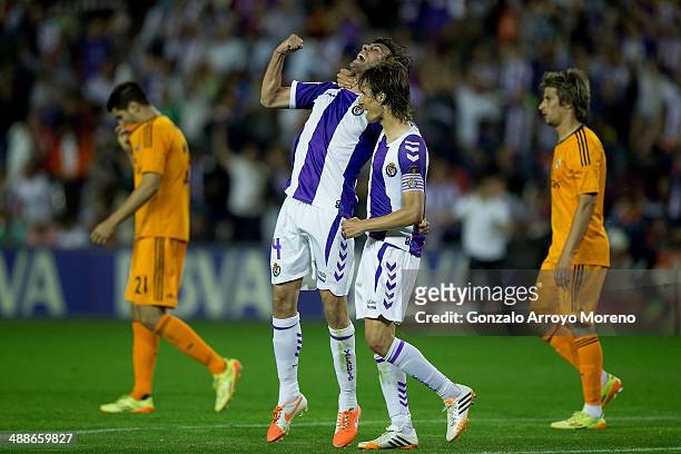 Alvaro Rubio of Real Valladolid CF celebrates their tie with his teammate Marc Valiente as Alvaro B. Morata and Fabio Coentrao of Real Madrid CF...