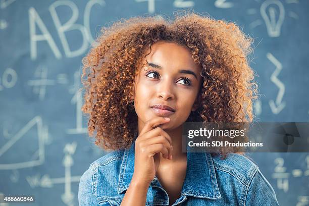 pretty african american teenage girl in front of blackboard - thinking student stock pictures, royalty-free photos & images