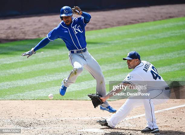 Jarrod Dyson of the Kansas City Royals jumps as he scores past the throw to Hector Ambriz of the San Diego Padres during the eighth inning of a...