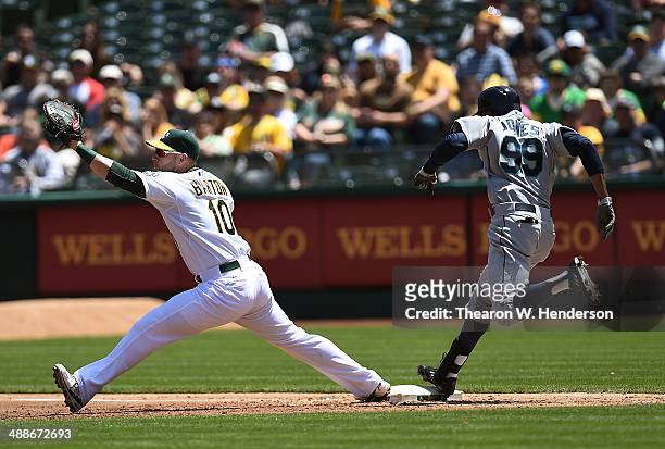 James Jones of the Seattle Mariners gets an infield hit, beating the throw to Daric Barton of the Oakland Athletics in the top of the third inning in...